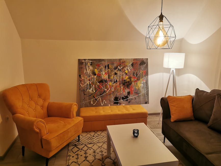 Cozy modern living room featuring a geometric pendant light, abstract wall art, and comfortable furniture.