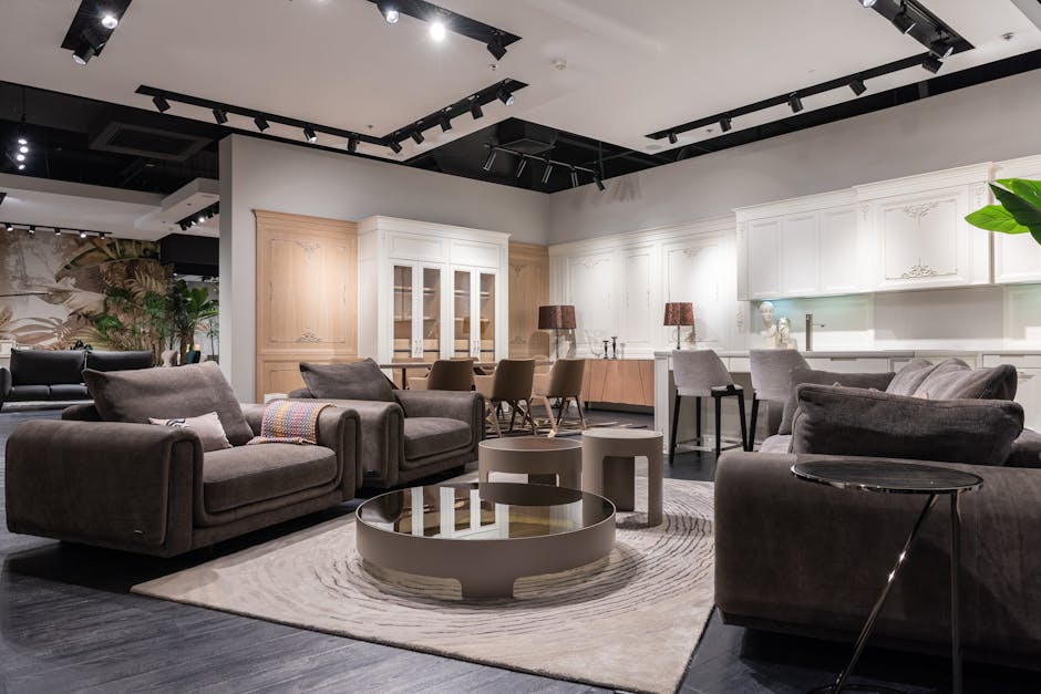 Interior of spacious furniture store with comfortable couches and armchairs and round coffee tables placed near kitchen furniture